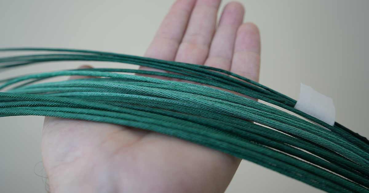A hand holding a handful of coiled green Visco fuse, demonstrating careful organization and handling.